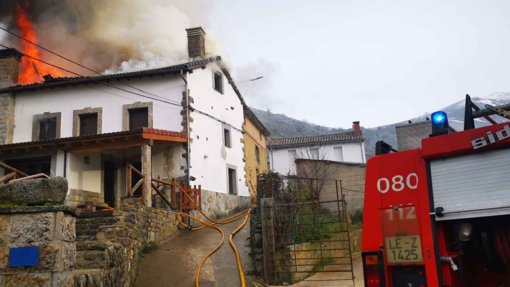 Los bomberos sofocando las llamas de una vivienda en un pueblo de León