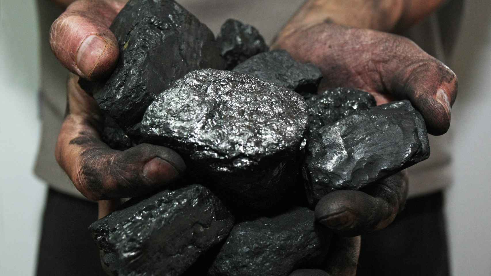 Un hombre sujeta carbón en sus manos