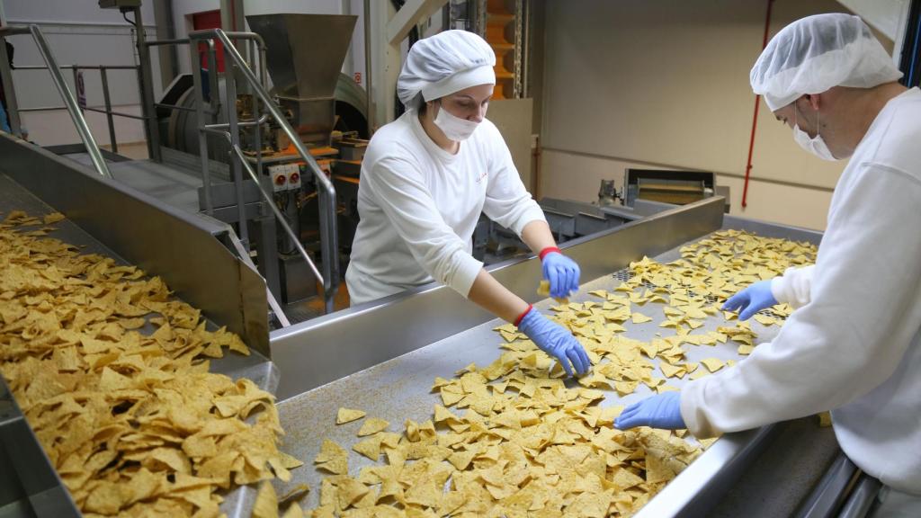 Imagen de dos trabajadores en la planta que Ibersnacks tiene en Medina del Campo (Valladolid).