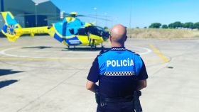 Un agente de la Policía Local de Peñaranda de Bracamonte, Salamanca, junto a un helicóptero de Sacyl