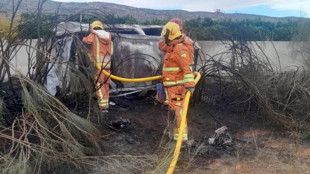 Los bomberos durante su intervención para apagar las llamas del vehículo