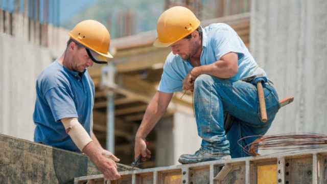 Dos empleados realizando trabajos en una construcción