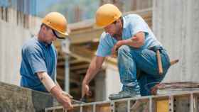 Dos empleados realizando trabajos en una construcción
