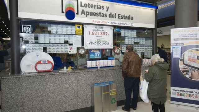Jubilados comprando décimos en una administración de lotería.