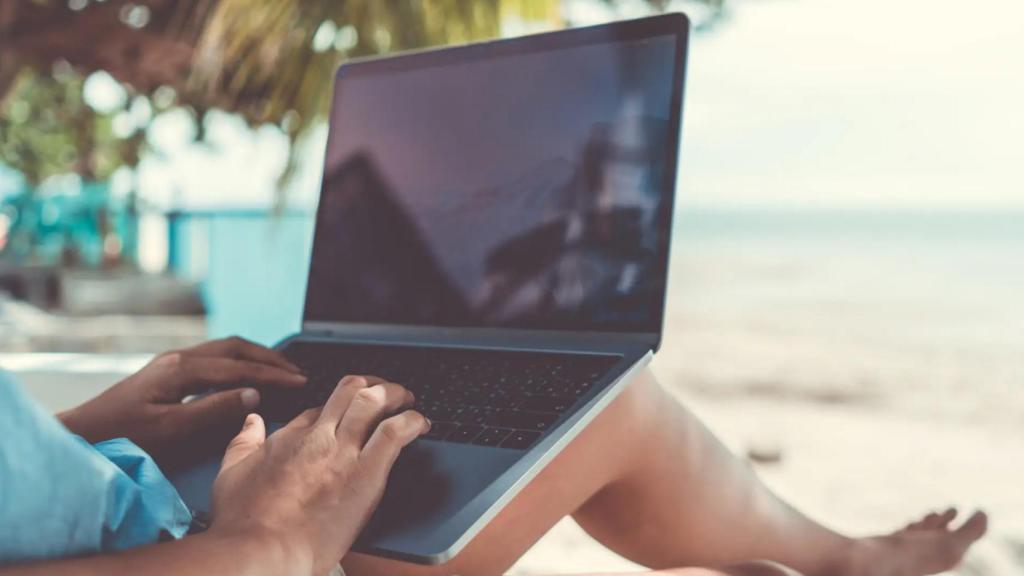 Una persona teletrabajando desde la playa