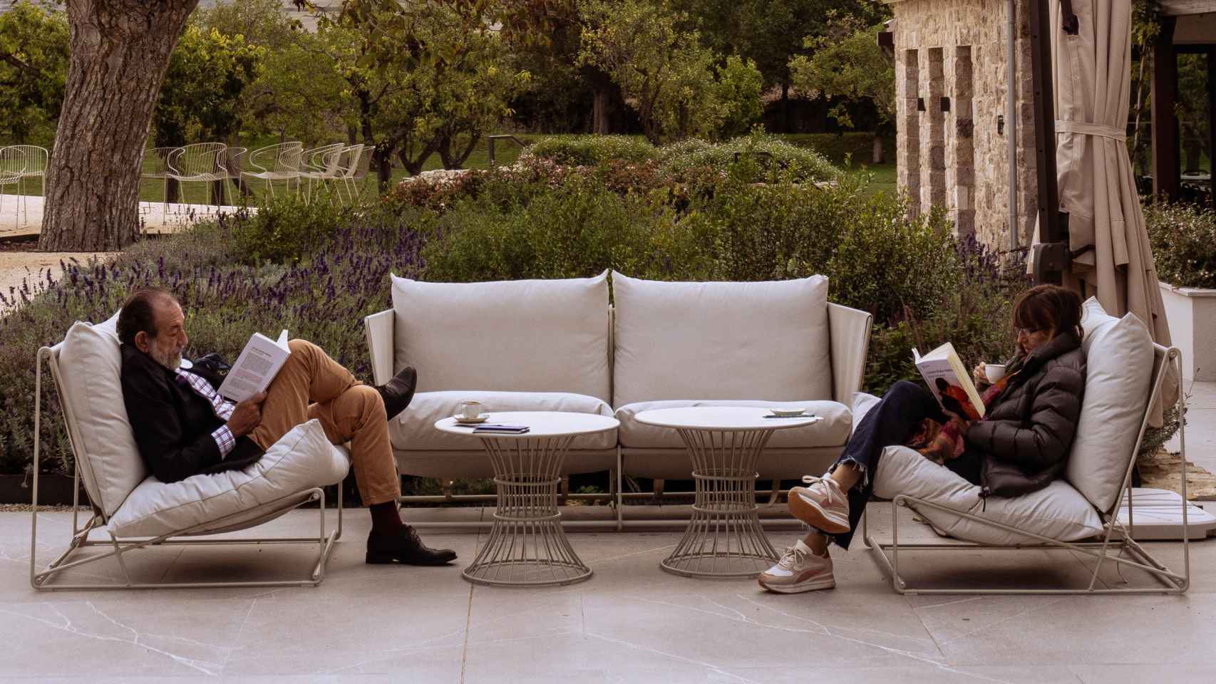 Dos asistentes a Remanso leen 'No te veré morir' en el jardín del Hotel Quinta San Francisco.
