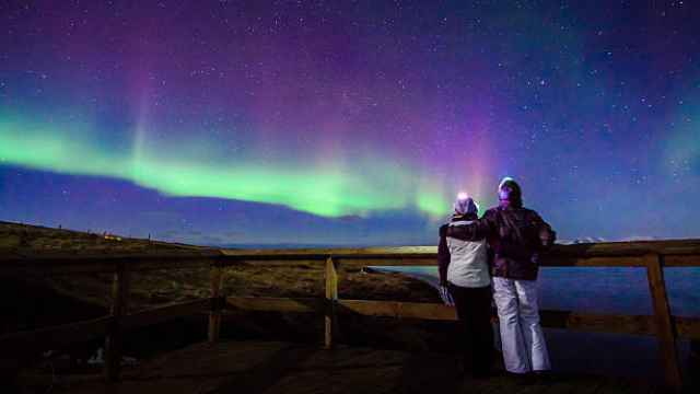 Una pareja disfrutando de una aurora boreal