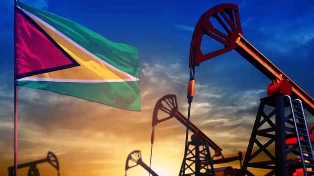 Bandera de Guyana con pozos petrolíferos.