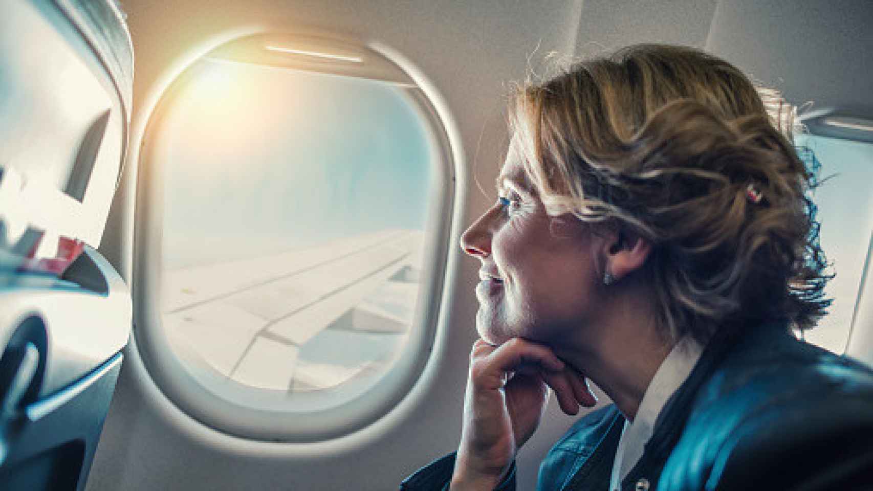 Una mujer con una sonrisa en el interior de un avión