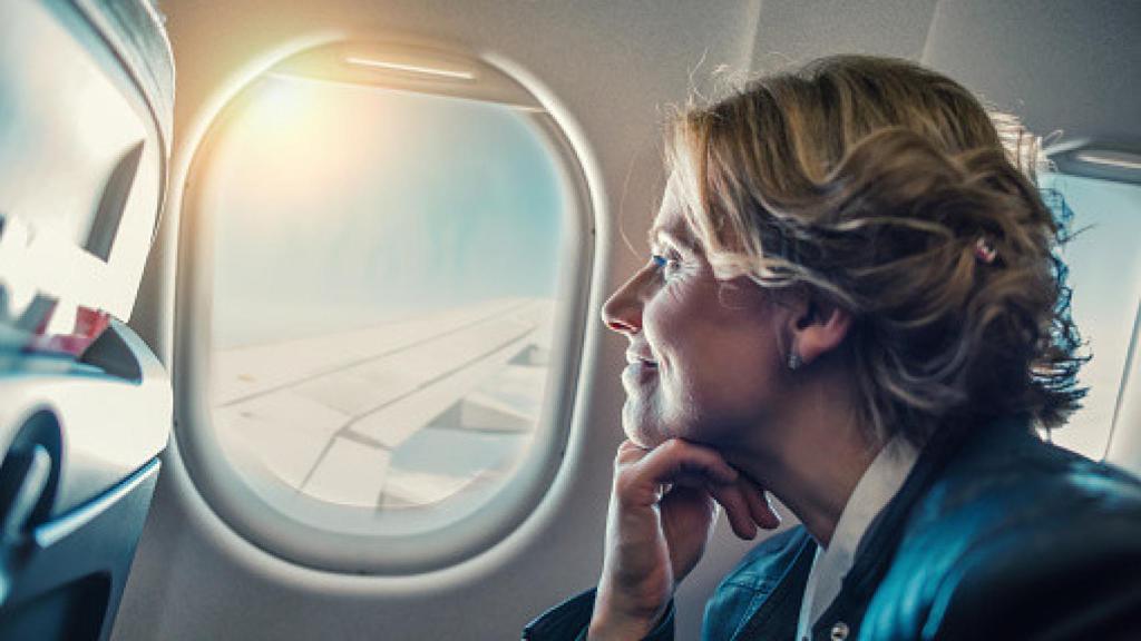 Una mujer con una sonrisa en el interior de un avión