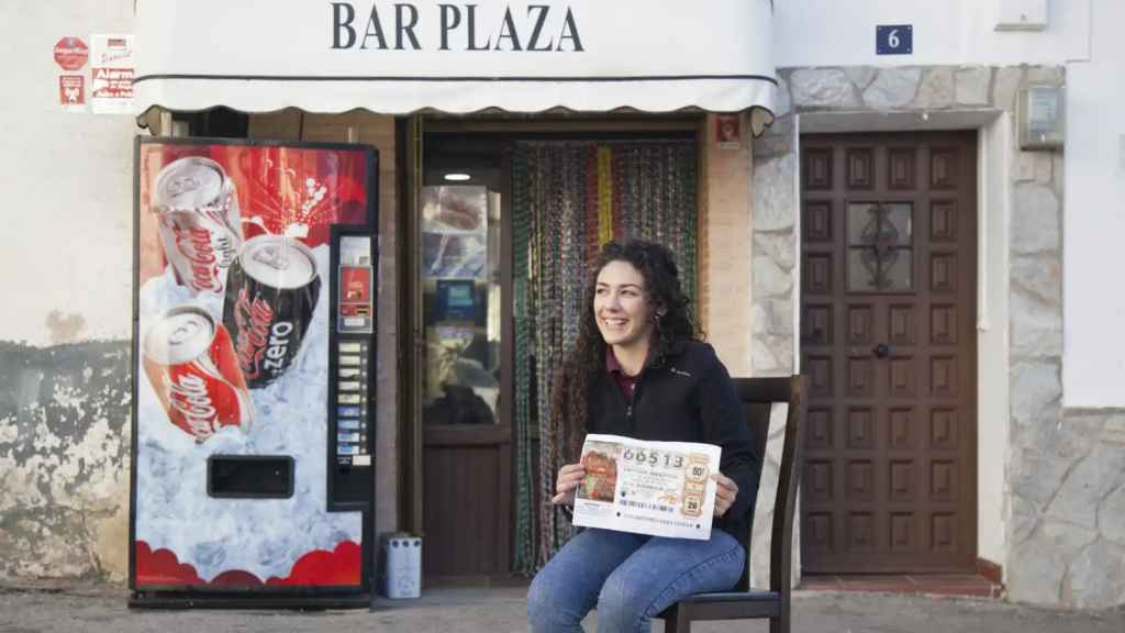 Una mujer posa con el número que le dio 400.000 euros, en una fotografía realizada en Brea de Tajo en 2016 tras el Sorteo.