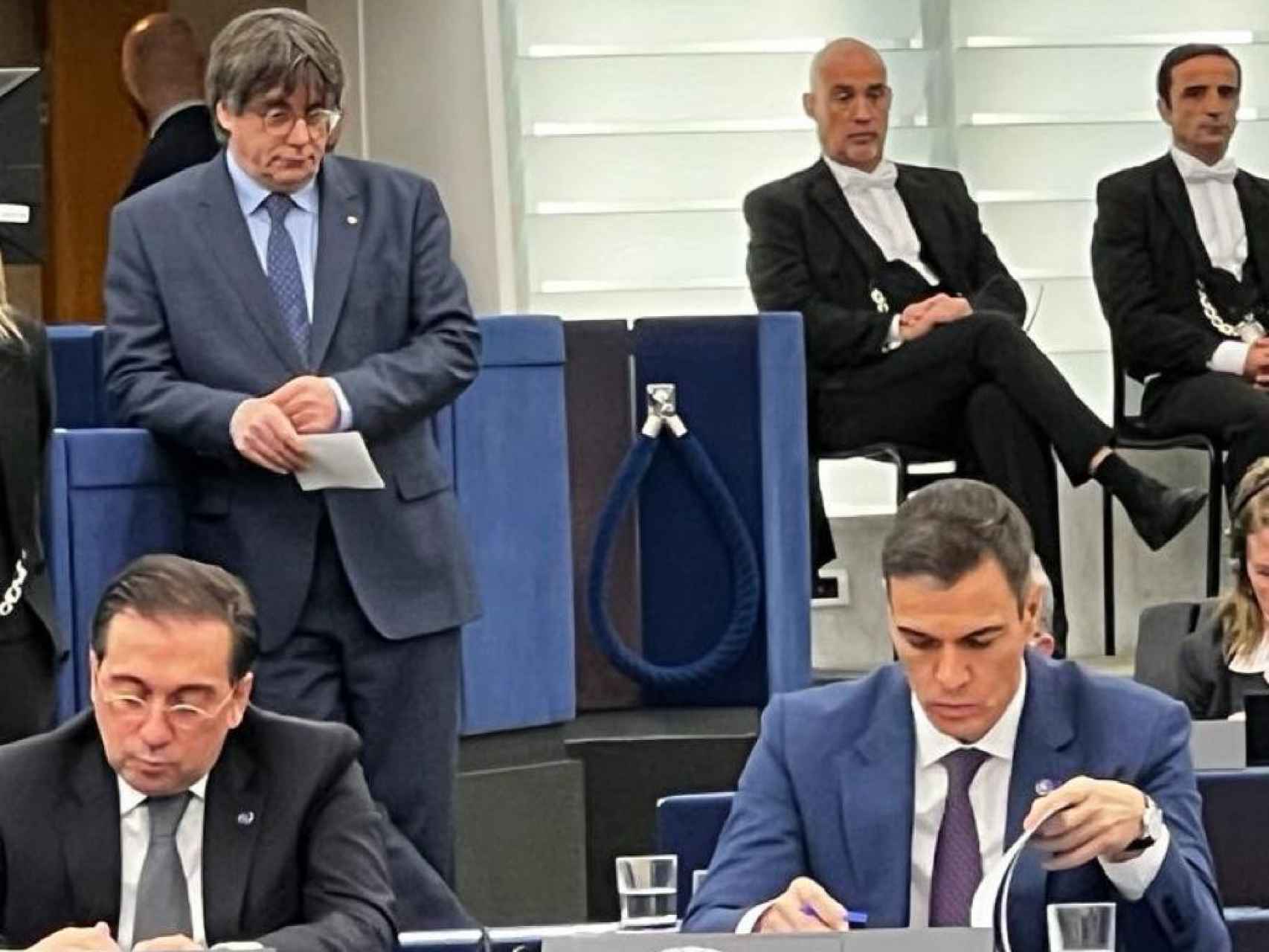 Puigdemont aguarda su turno para intervenir en el Parlamento Europeo, a espaldas de Sánchez y de Albares, el pasado mes de diciembre.