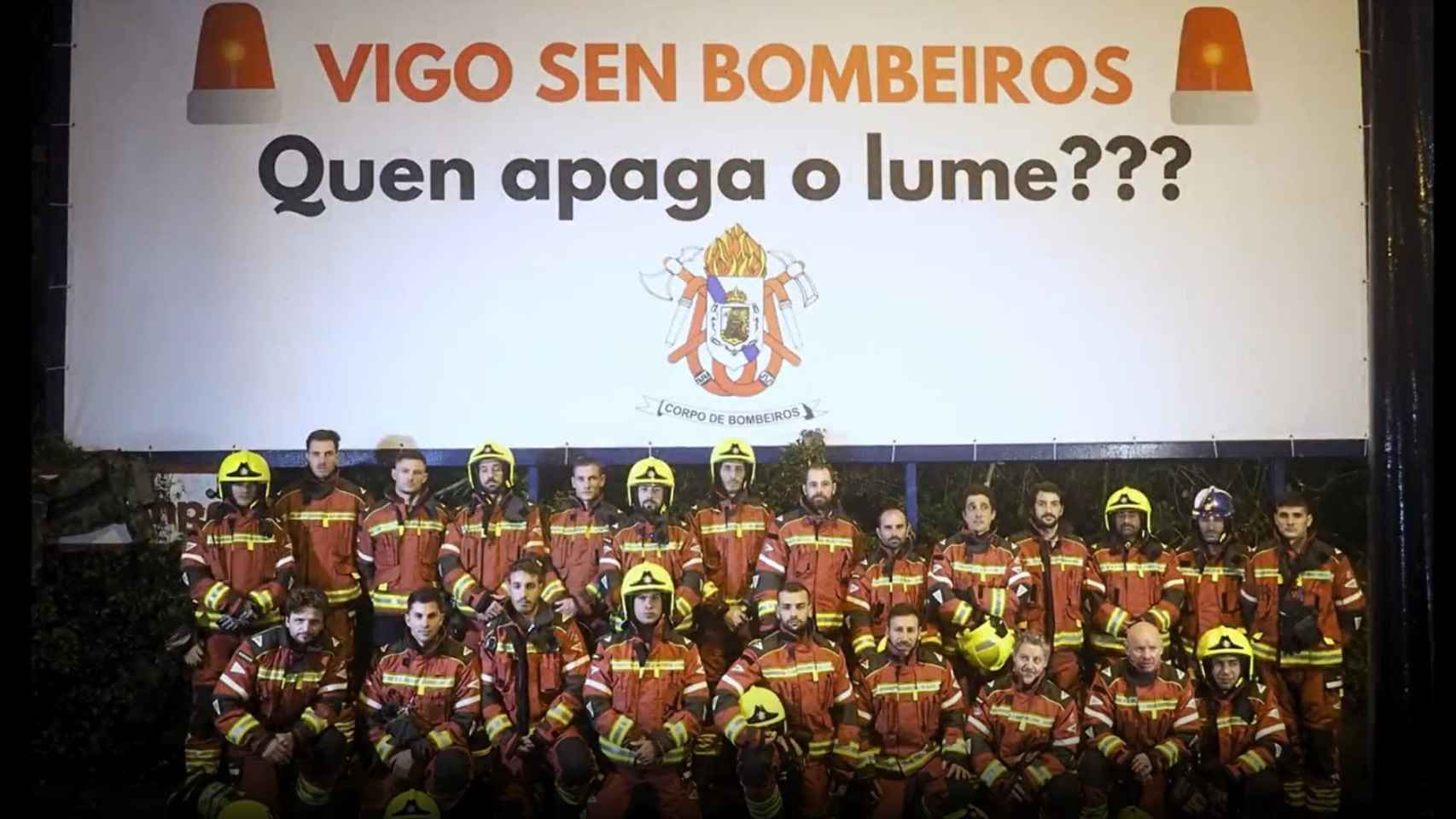 El cuerpo de Bomberos de Vigo posan ante la valla publicitaria.
