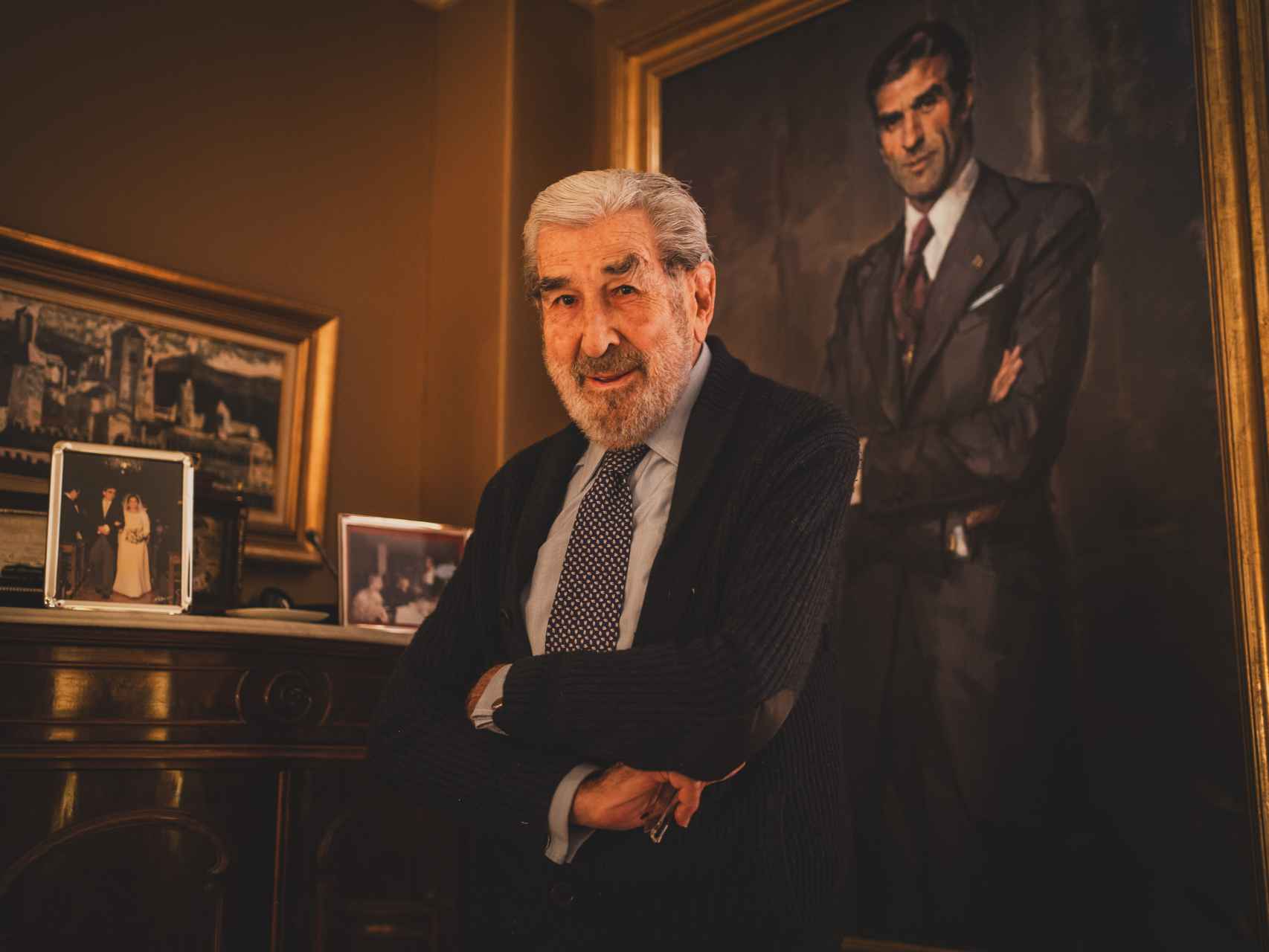 Fernando Suárez, en su casa, con un retrato suyo de juventud a la espalda. Hoy tiene 90 años.