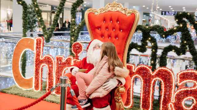 Una niña sentada en el regazo de Papá Noel en Vallsur