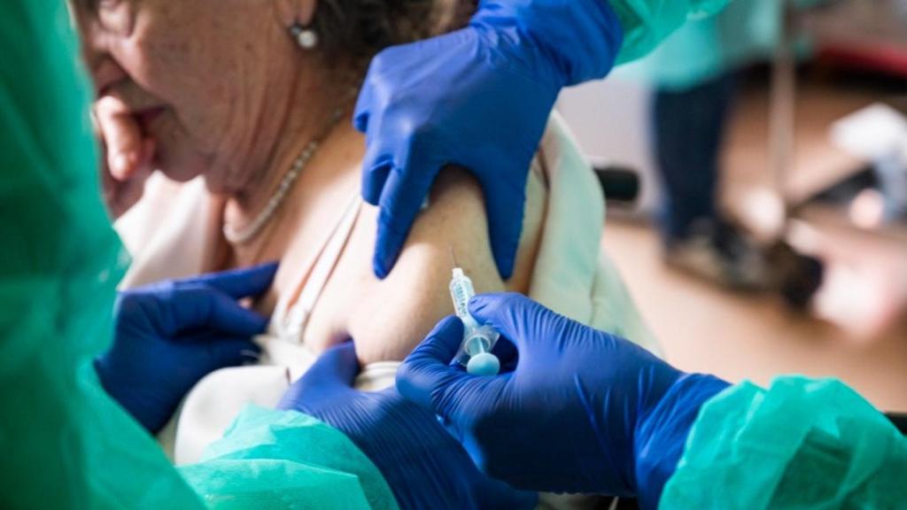 Una mujer recibe la vacuna contra la gripe.