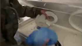 Un militar israelí sacando munición de una incubadora en un hospital de Gaza.