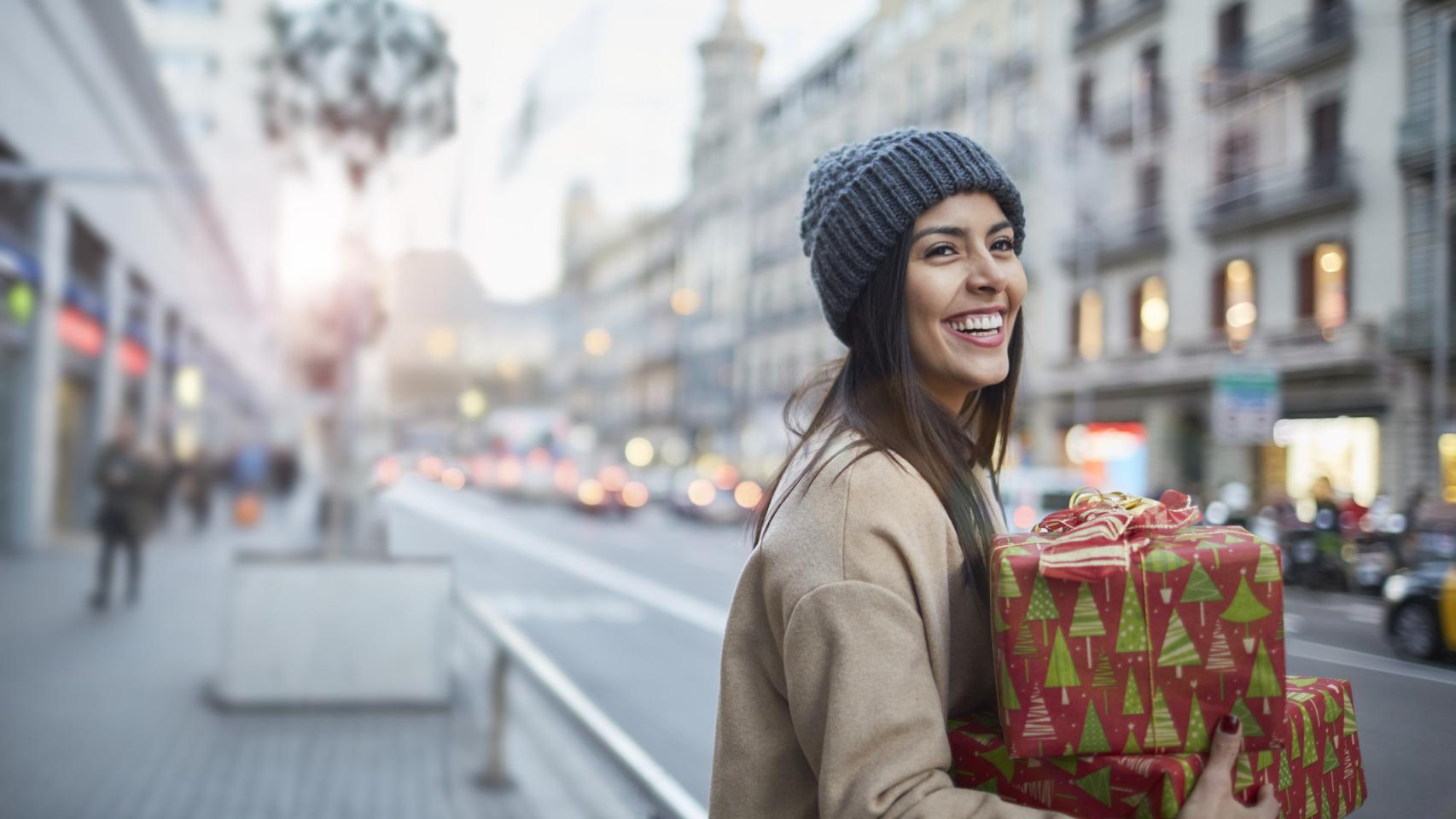 Imagen de una chica cargada con regalos