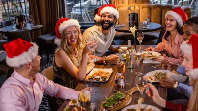 Un grupo de amigos reunido cenando en Navidad