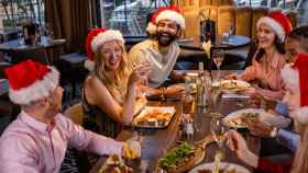 Un grupo de amigos reunido cenando en Navidad
