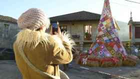 Una persona toma una fotografía frente al árbol de Navidad de Ousende hecho con ganchillo, a 18 de diciembre de 2023.