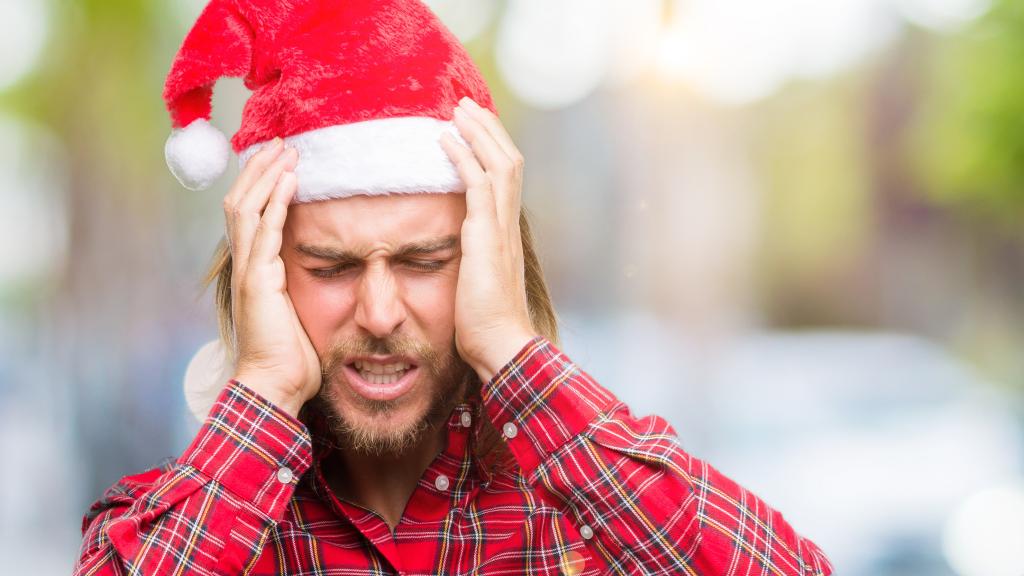 Un hombre con migrañas en Navidad.