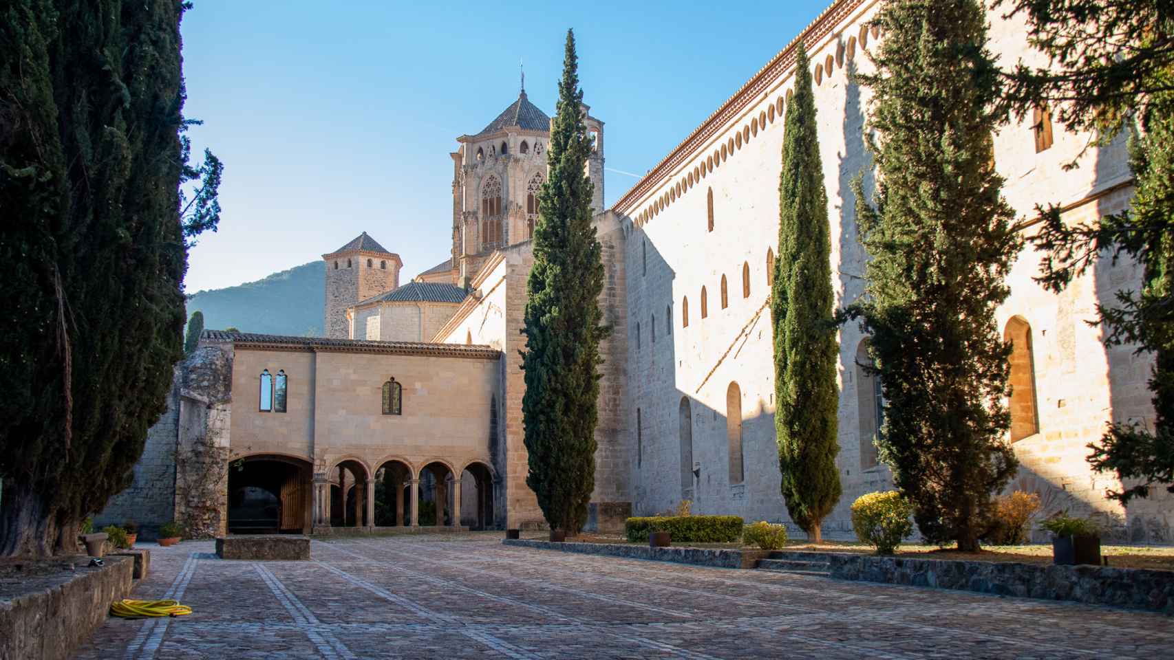 El interior de la zona de clausura destinada a los monjes cistercienses; de fondo, el característico cimborrio del monasterio de Poblet.