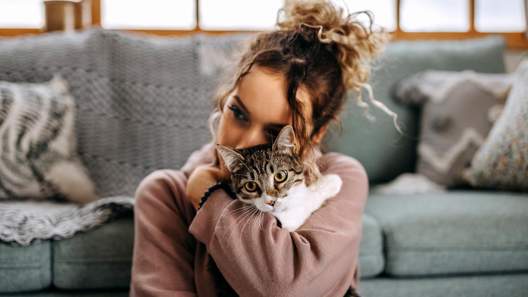 Imagen de una mujer abrazando a un gato.