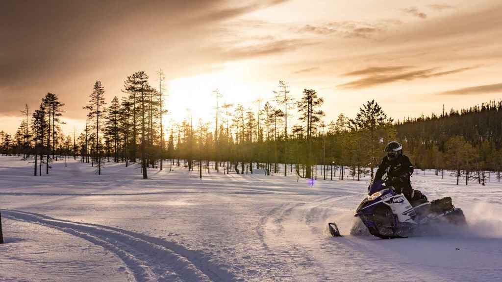 Paseo en moto de nieve por el paisaje de Laponia.