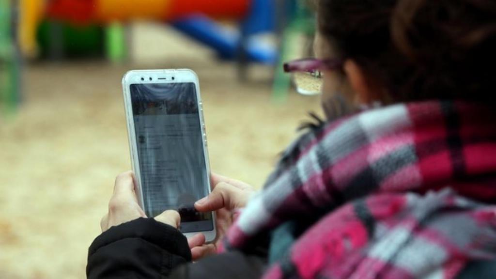 Una alumna con el móvil en clase