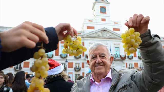 Varias personas muestran racimos de uvas en las Preuvas de 2022 en la Puerta del Sol.