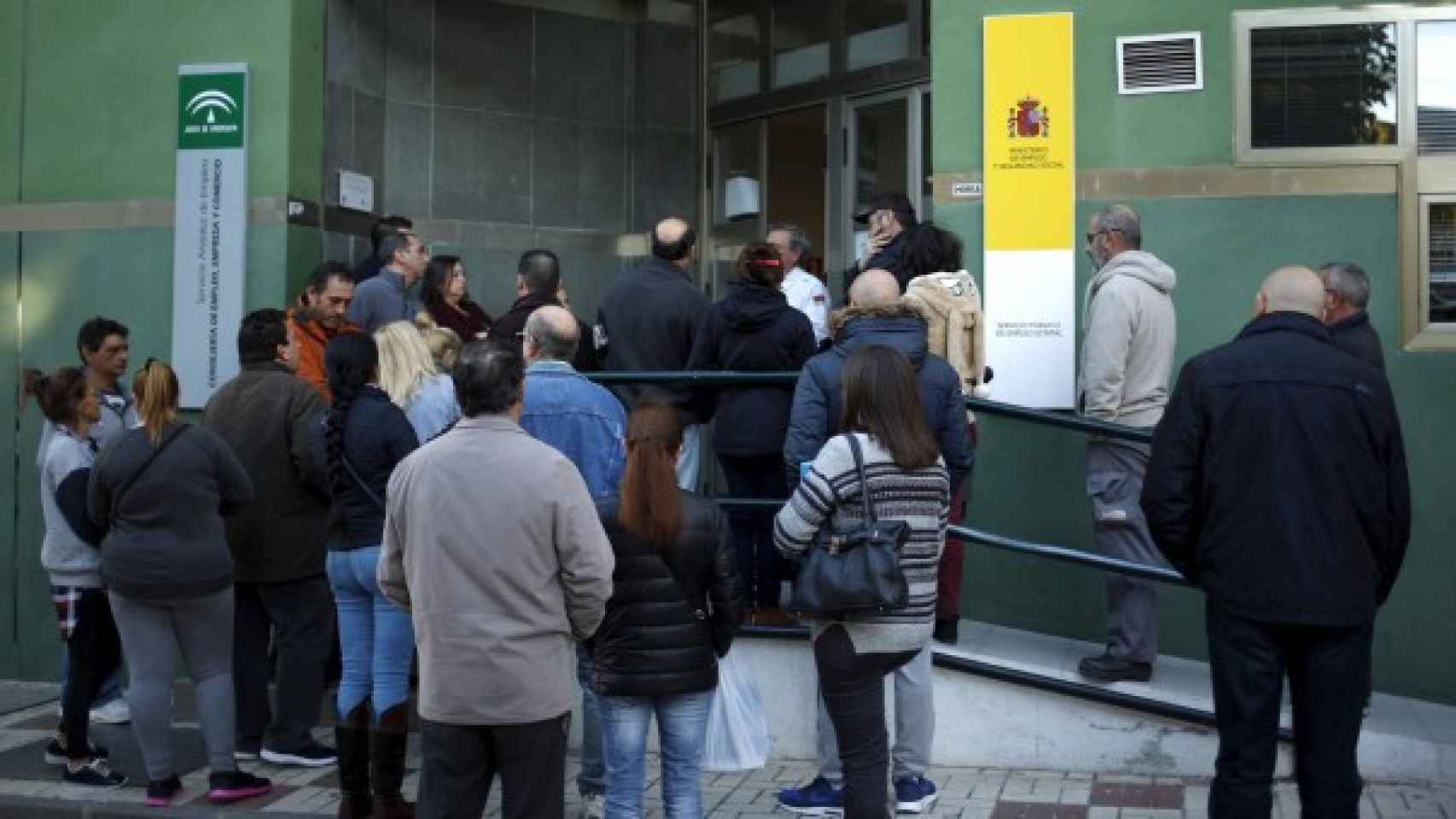 Personas esperan delante de una oficina del Servicio Andaluz de Empleo.
