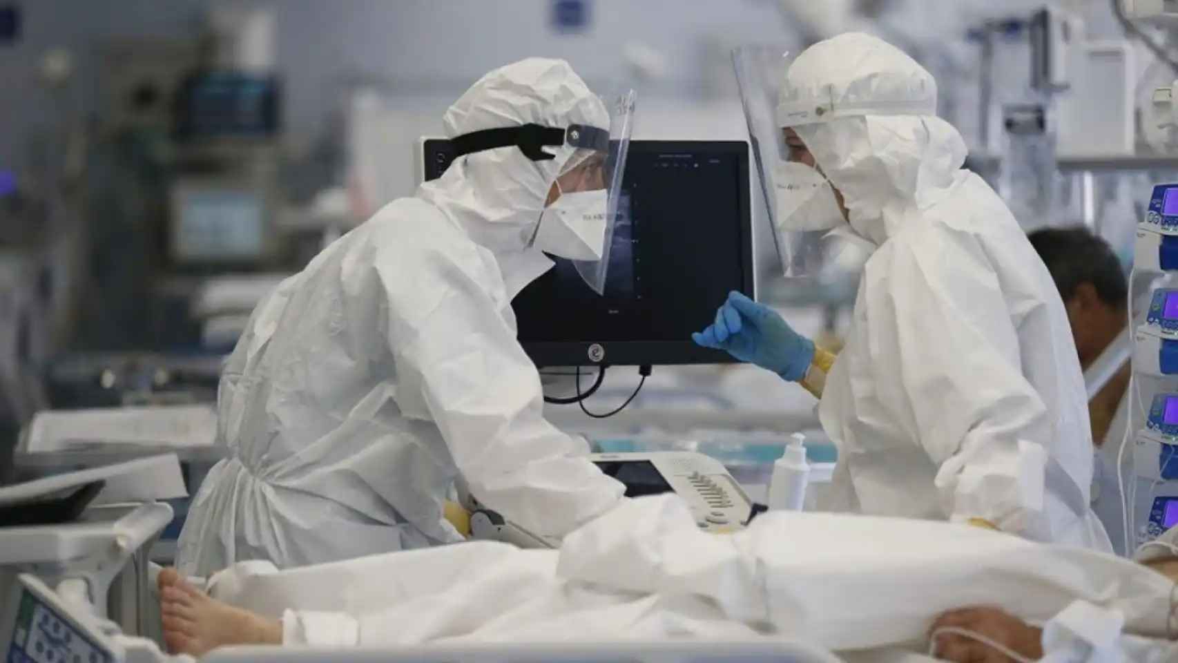 Imagen de archivo. Dos sanitarios trabajan vestidos con equipos de protección individual durante la pandemia.