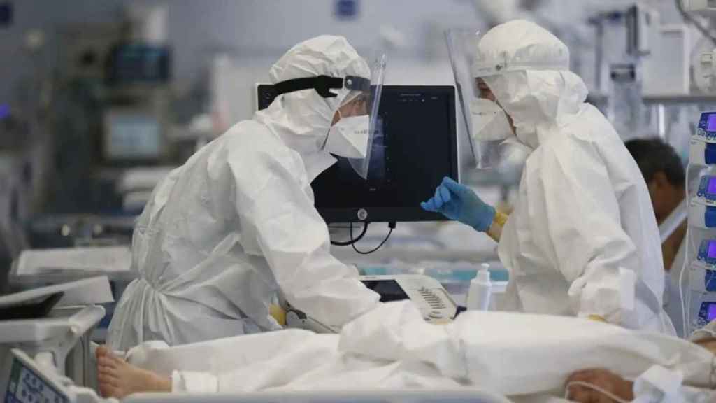Dos sanitarios trabajan vestidos con equipos de protección individual durante la pandemia.
