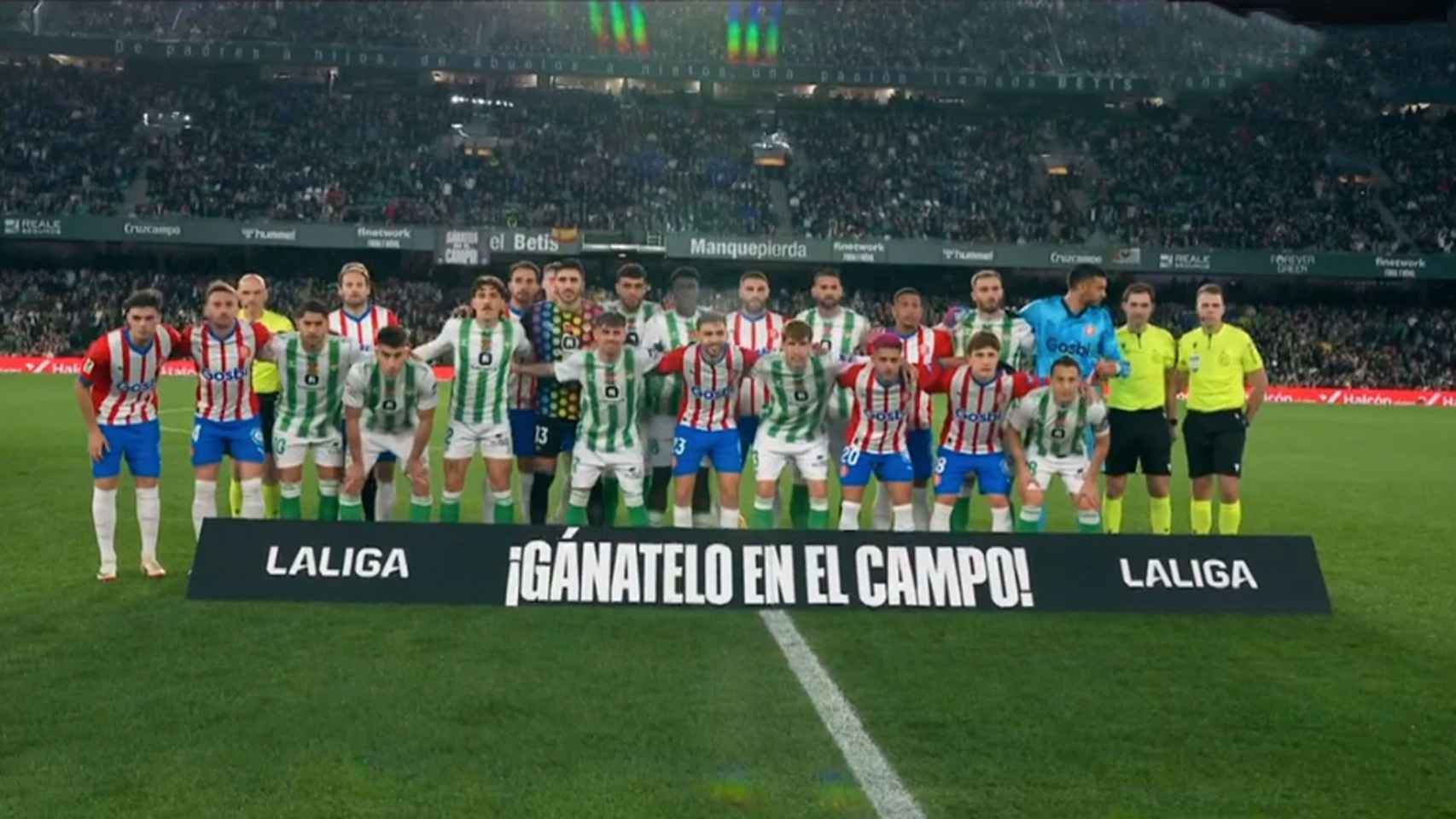 Los futbolistas de Girona y Betis posando con el lema ¡Gánatelo en el campo!