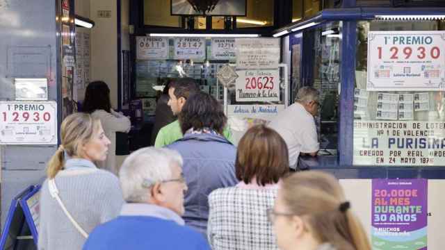 Personas haciendo cola para comprar lotería en una administración de Valencia. Efe / Ana Escobar