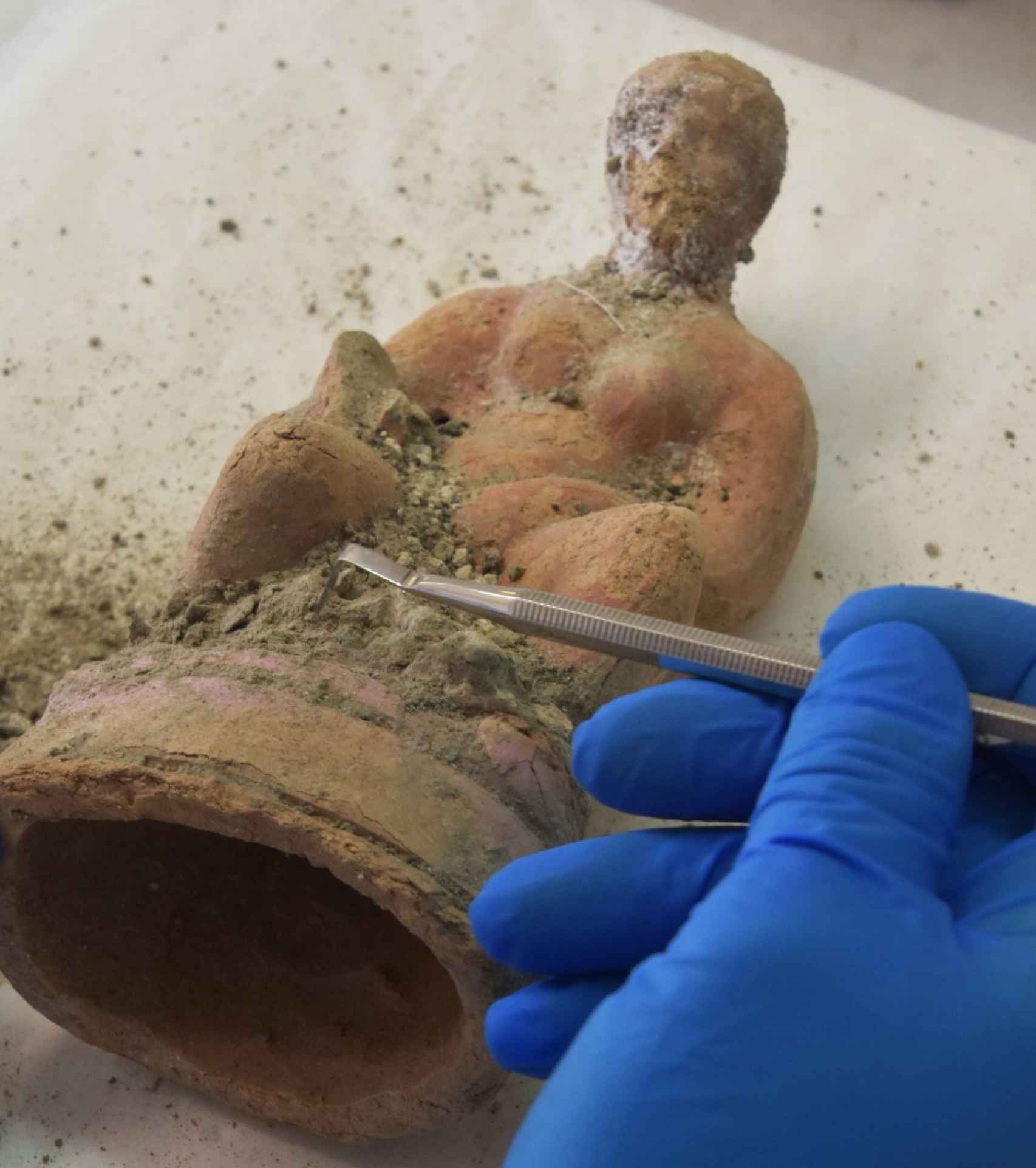 Arqueólogo limpiando una de las estatuillas descubiertas