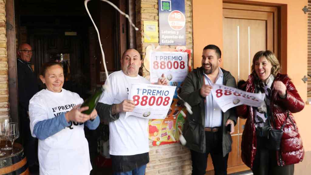 El dueño del bar La Behetría de Becerril de Campos, Migue Ángel Ruiz(2I), celebra el décimo del Gordo que ha vendido a través de la máquina expendedora