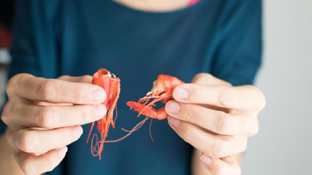 Imagen de una persona comiendo gambas