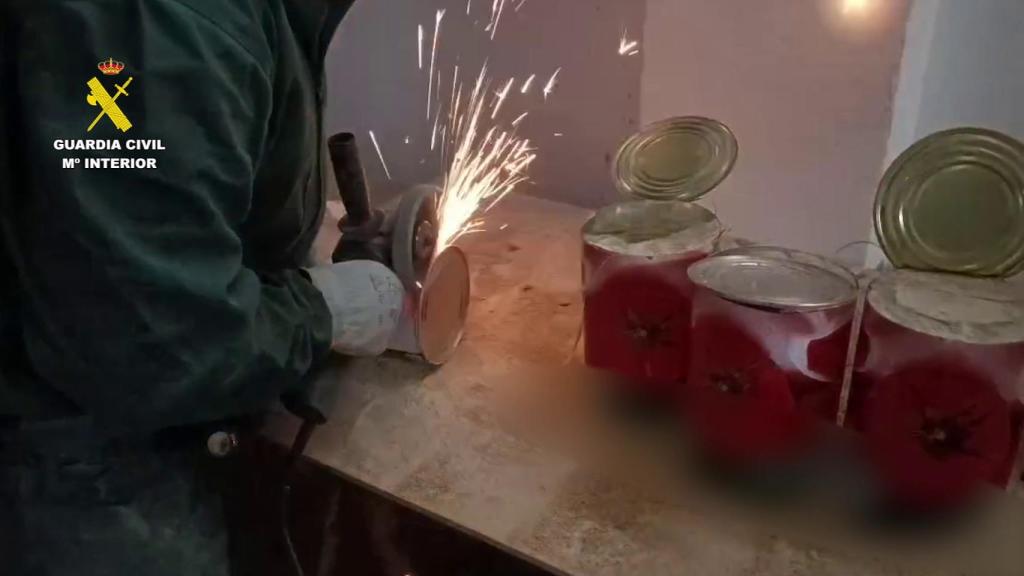 La Guardia Civil abriendo las supuestas latas de tomate.