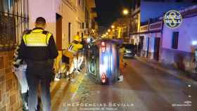 Vehículo volcado en una calle de Torreblanca en Sevilla.