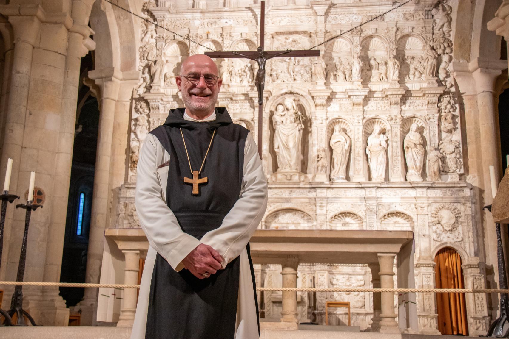 El abad Octavio Vilà, abad del monasterio, sonríe frente al retablo de la iglesia de Poblet.