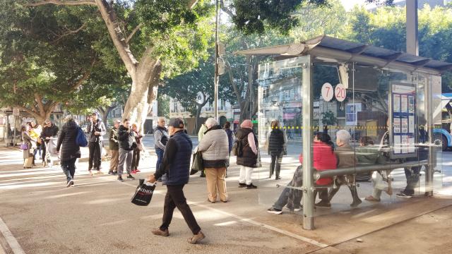 Un grupo de pasajeros, junto a una de las paradas de la Empresa Malagueña de Transportes (EMT) en la Alameda Principal.