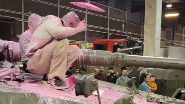 Dos activistas tiñen de rosa un tanque del Ejército en la feria Expojove de Valencia. EE