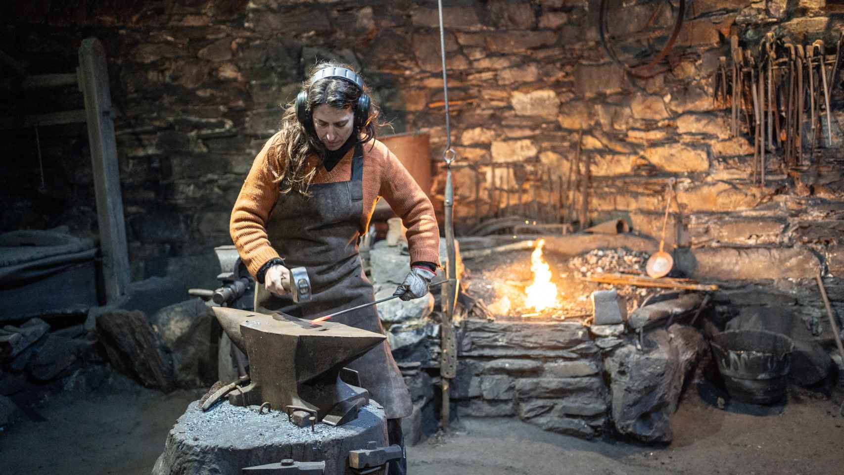 Paz Prieto utiliza el martillo para forjar una pieza sobre el yunque de la herrería situada en el único mazo hidráulico que queda en España.