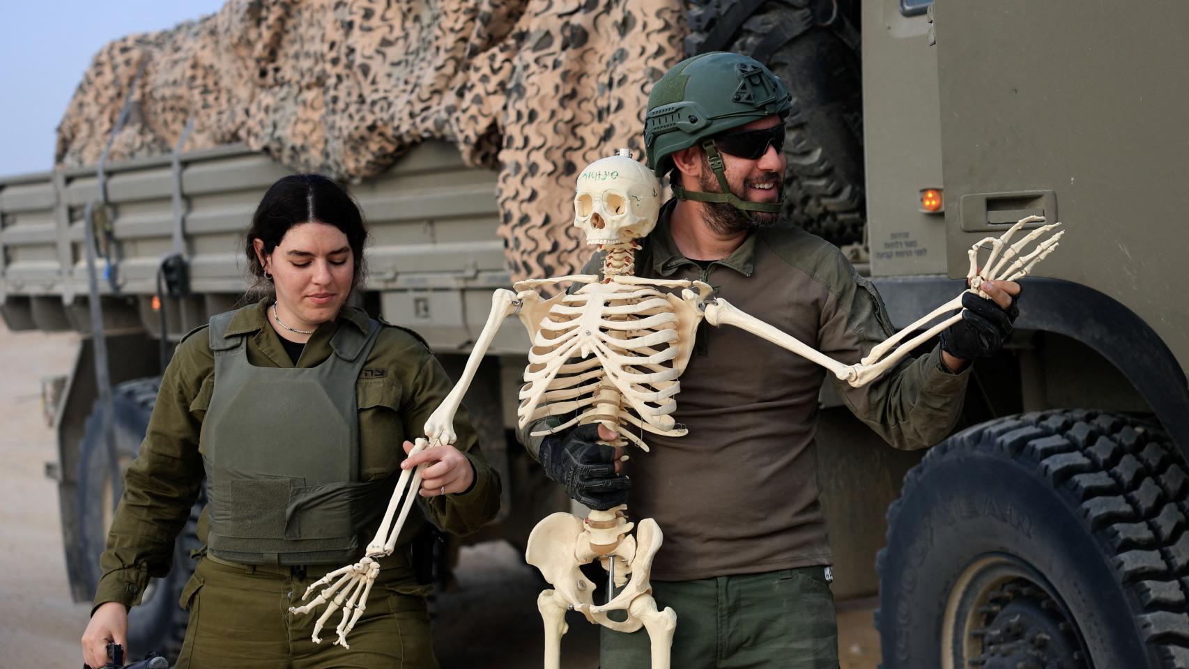 Dos soldados israelíes sostienen un esqueleto de plástico que encontraron en Gaza, este miércoles.