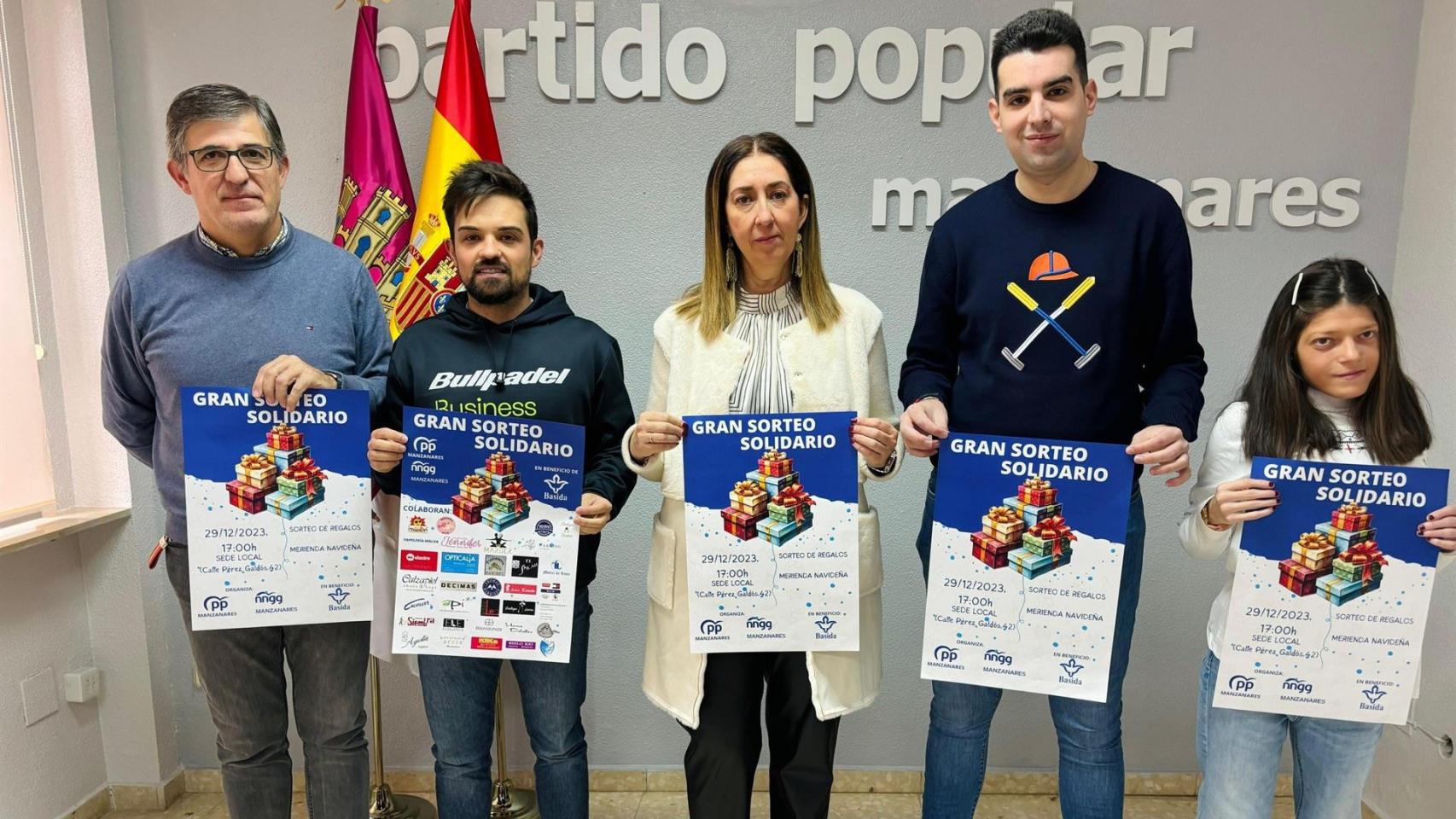 Miembros del Partido Popular de Manzanares con el cartel del acto cancelado