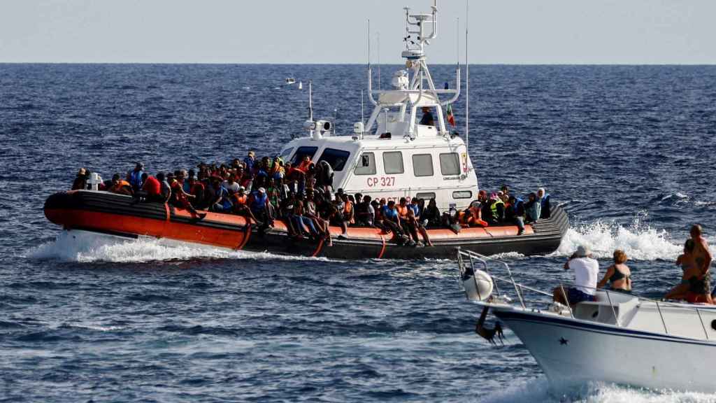 Un barco de la Guardia Costera italiana transporta inmigrantes rescatados en el mar.