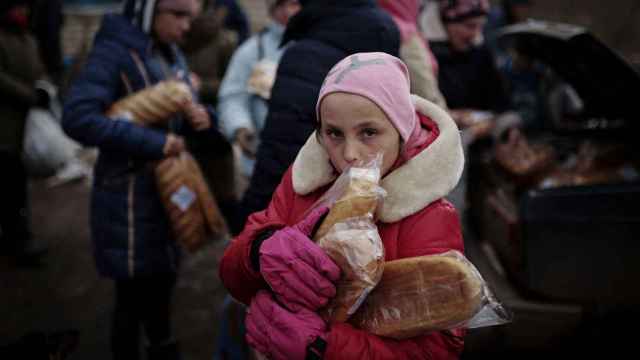La pequeña Anastia recoge comida repartida por los voluntarios cerca de Jersón.