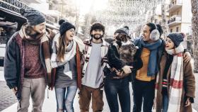 Imagen de un grupo de amigos en la calle con lucen de Navidad